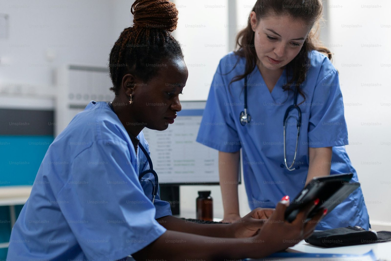 Healthcare team collaborating around a tablet in a clinical office